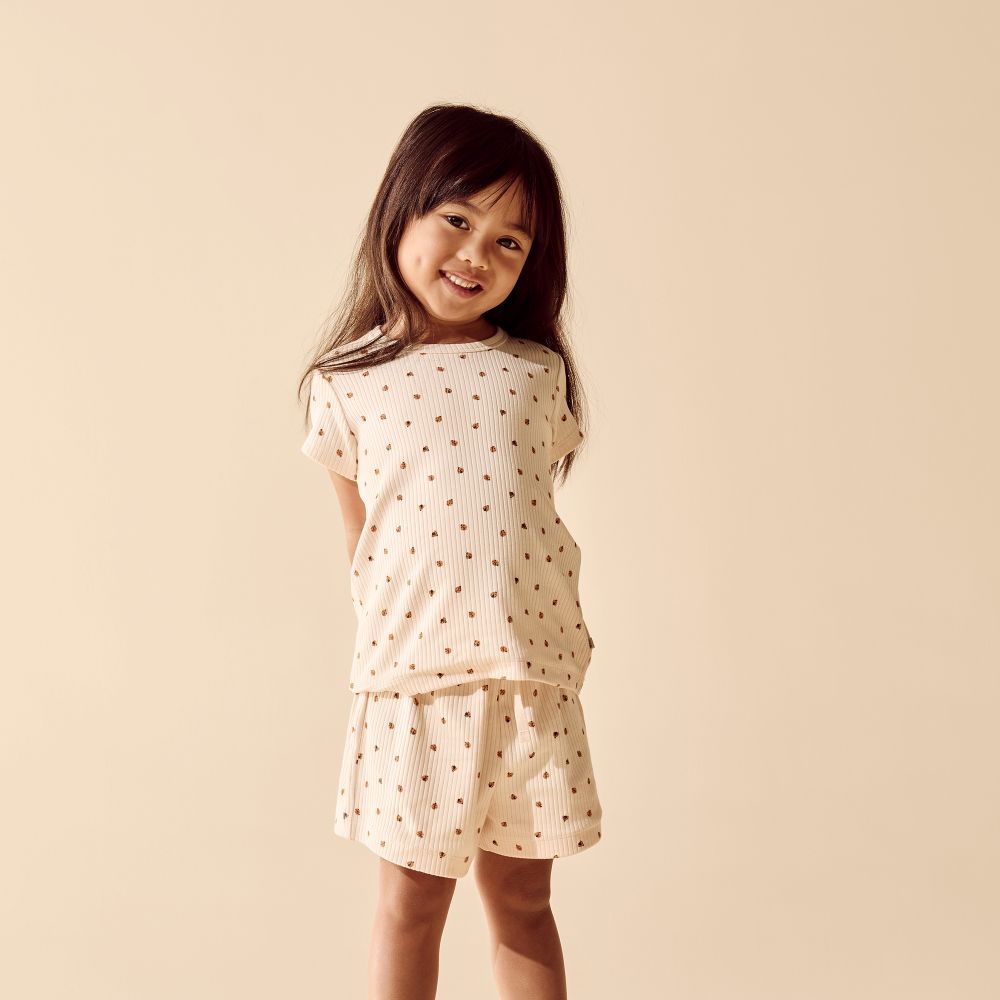 Wilson & Frenchy Little Lady Bugs Organic Short Sleeved Pyjamas at Cerise. Made from GOTS-certified organic cotton in a lightweight drop-needle fabric, this two-piece kids’ sleepwear set offers breathable comfort for a restful night’s sleep. The set includes a short-sleeved T-shirt and relaxed, mid-length shorts, making it an easy and practical choice for warmer weather.