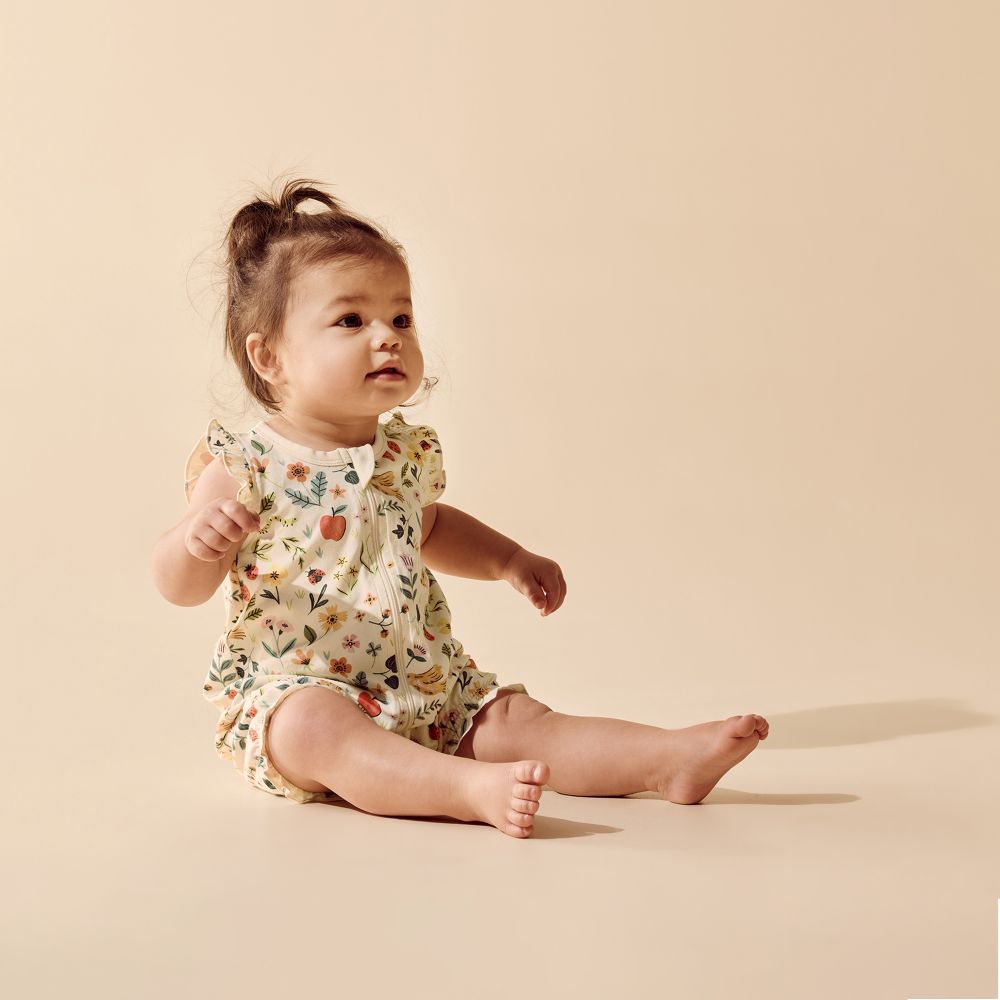 Wilson & frenchy Summer Garden Organic Ruffle Zipsuit at Cerise. Featuring an enchanting all-over Summer Garden print, this baby zipsuit is finished with adorable ruffle cap sleeves for a playful, feminine touch. The comfortable design allows plenty of freedom for little ones to move, play and explore.

A convenient two-way zip through the centre front makes dressing and nappy changes quick and easy, while shirring around the leg openings provides a flexible, comfortable fit that accommodates growing babies