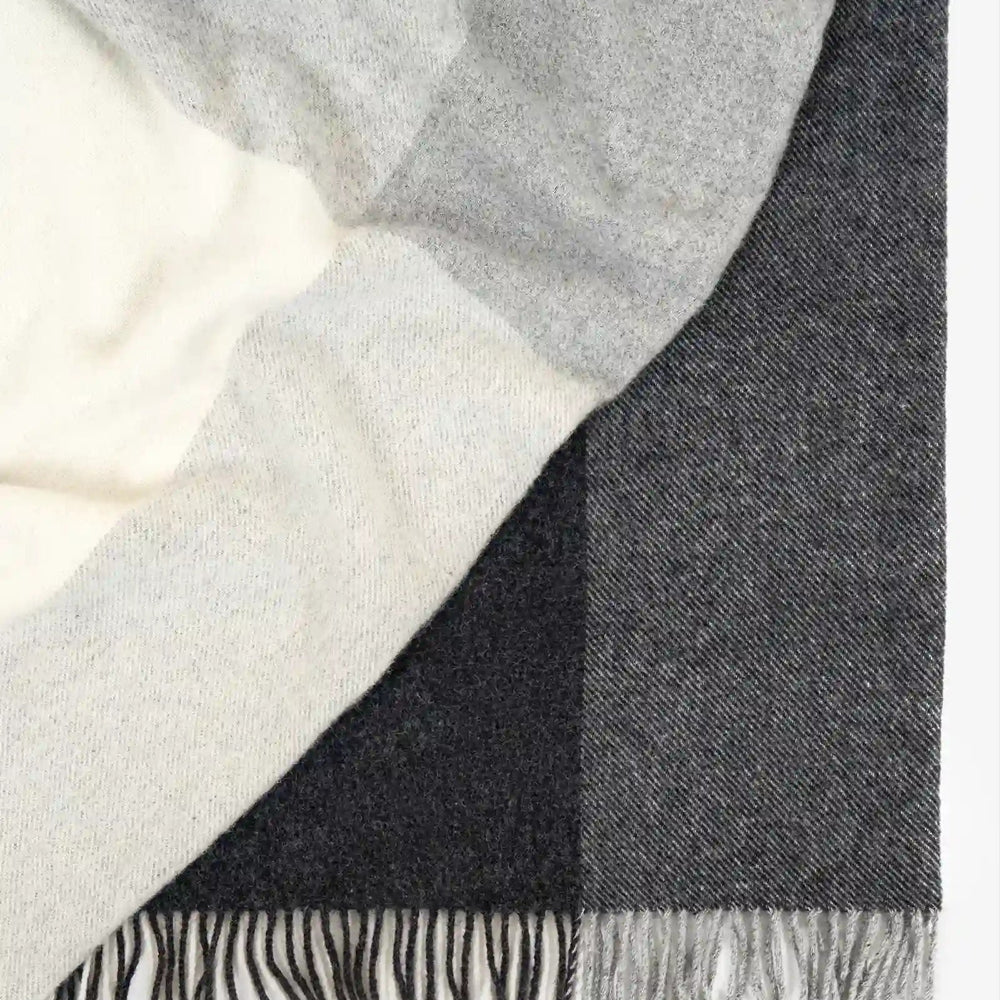 Weave Bayswater Charcoal Throw at Cerise.  Made in 100% New Zealand Wool in a check design in varying shades of charcoal.  Has fringed ends and throw measures 150cm x 240cm