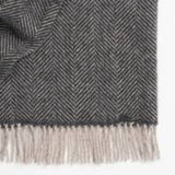 Weave Lerwish 100% NZ wool throw in a charcoal herringbone pattern with tassels