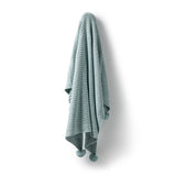 A beautiful Wilson & Frenchy newborn baby gift, this luxuriously soft knit blanket at Cerise is designed to provide comfort and warmth from day one.  A gorgeous Duck Egg colour with pom poms embelishing the corners this blanket is made from a premium blend of organic cotton, bamboo, and wool, it combines the natural breathability of cotton, the silky softness of bamboo, and the gentle insulation of wool.