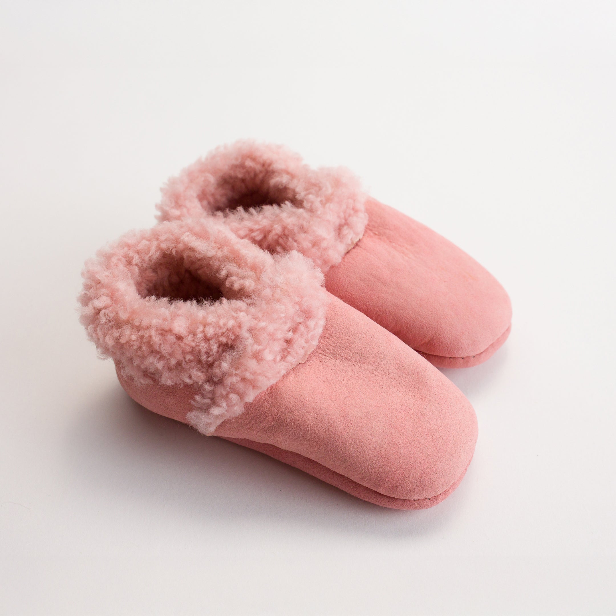 Woolbabe Lambskin Booties in Dusk - a soft pink colour at Cerise. Made in New Zealand  and avaialbe in sizes 0 - 2 years.