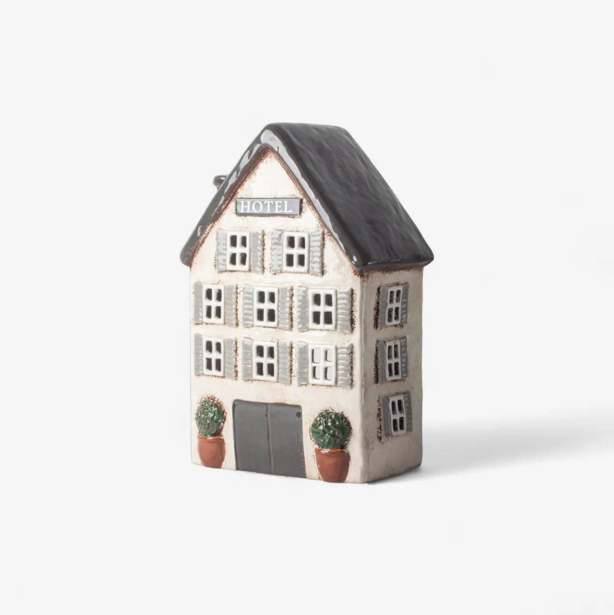 French Country Collections The Village Hotel Ceramic Tea Light at Cerise. Featuring detailed windows, architectural styling and a hand-finished textured surface, The Village Hotel Tea Light has a beautifully collected, vintage-inspired feel. Place it on a mantel, shelf, sideboard, console or bedside table to create a warm and inviting ambience in any room.