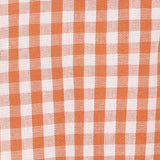 Orange and white sleeveless baby romper suit with wooden buttons