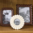 Hand carved ivory coloured round photo frame in a grouping ith other fames
