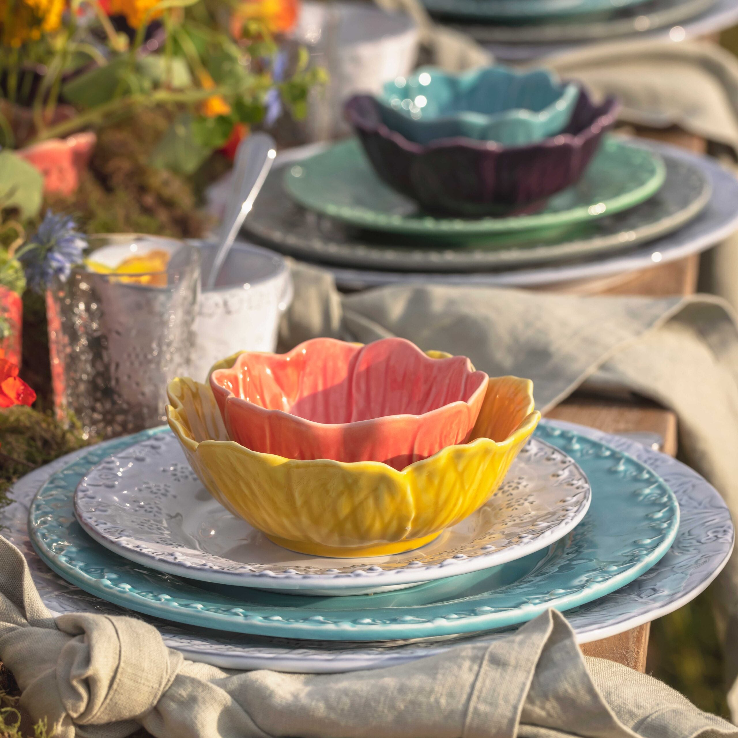 Colorful ceramic bowls and plates on a table with a floral background