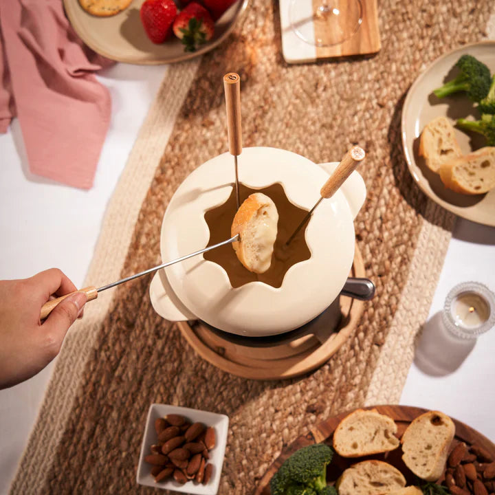 Beige coloroued fondue set on wooden base with wooden handle forks