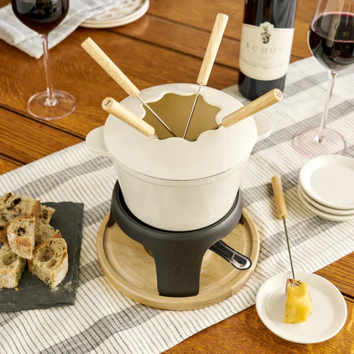 Beige coloroued fondue set on wooden base with wooden handle forks
