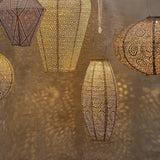 Group shot of hanging lanterns in different shapes at night time showing glow