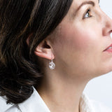 Model wearing silver drop earrings in a circular shape featuring the New Zealand Kereru Bird