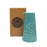 Blue coloured ceramic handleless jug with embossed kina design