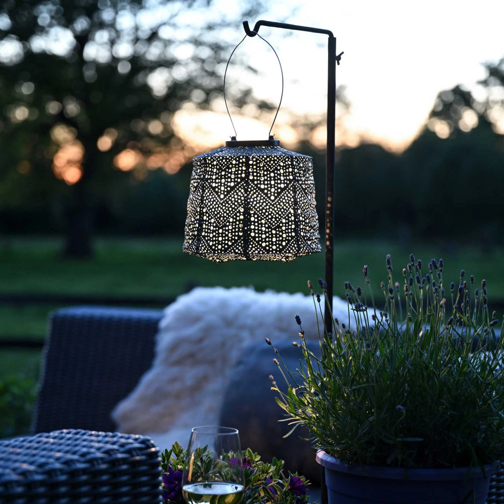 Hanging lumiz lantern in lampshade shape in verson green colour in night outdoor setting