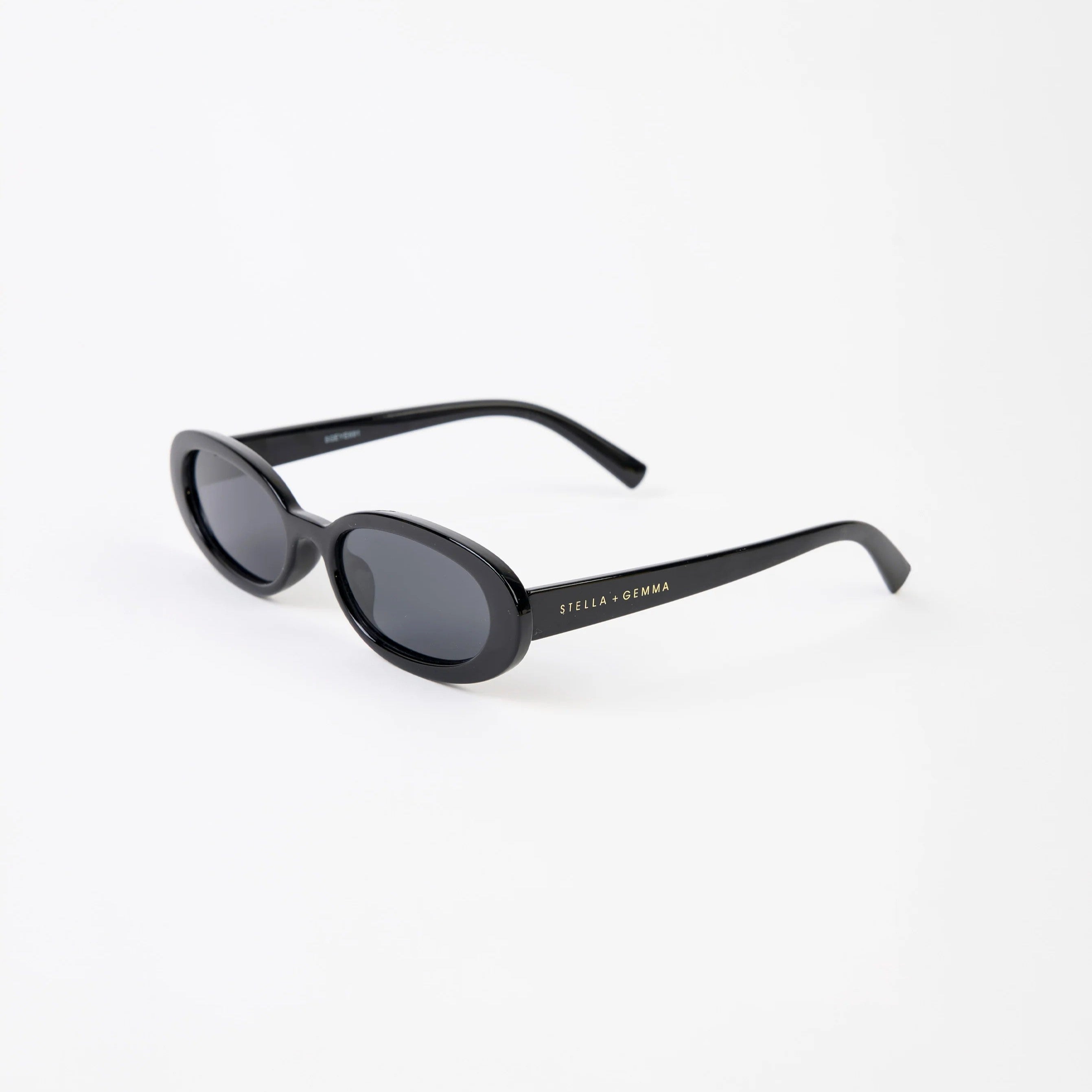 Black oval sunglasses on a white background side view showing stella and gemma branding on arm