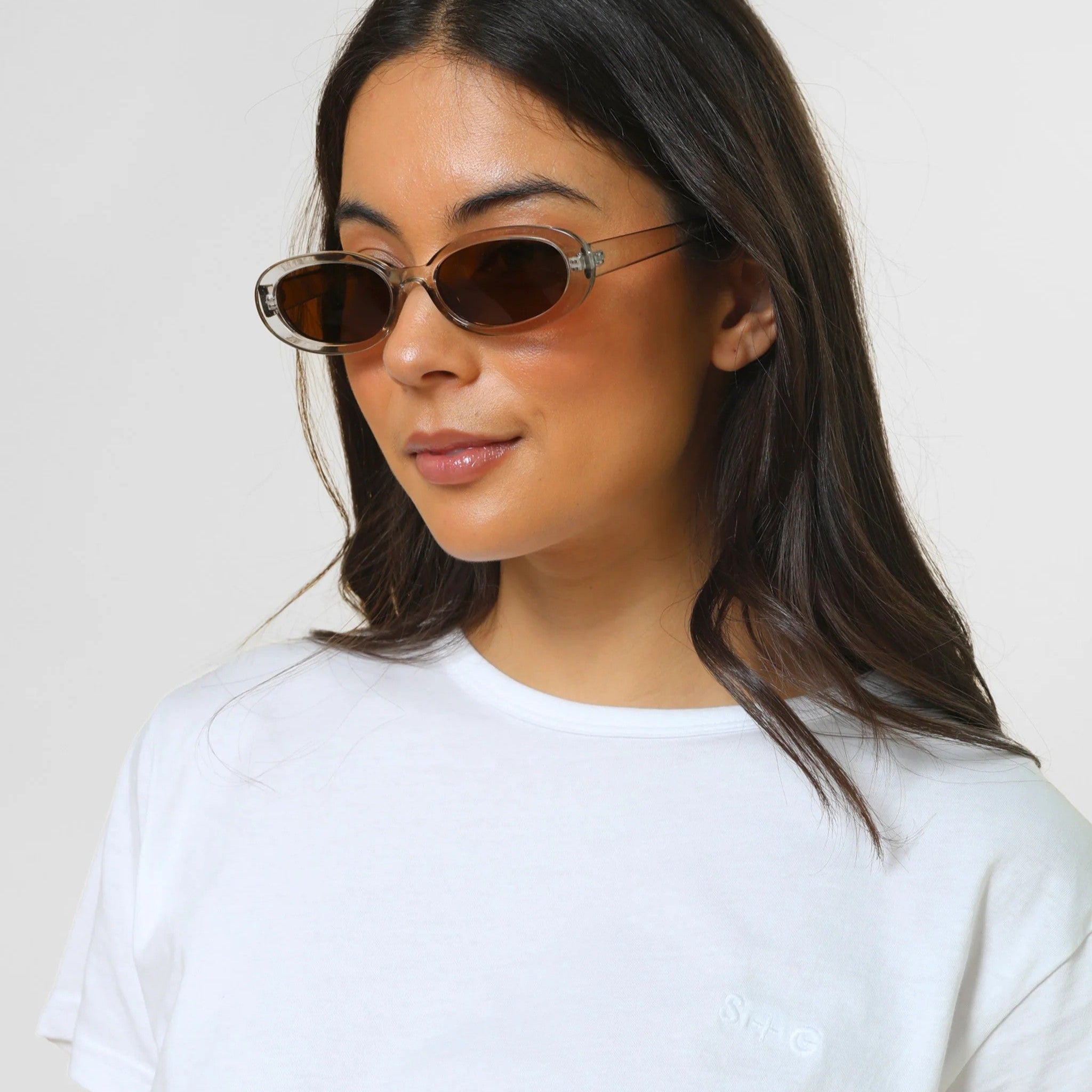 Gir wearing transparent light grey sunglasses in oval shape lens