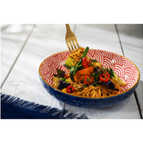 Colorful dish with noodles and vegetables on a white tablecloth