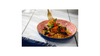 Colorful dish with noodles and vegetables on a white tablecloth