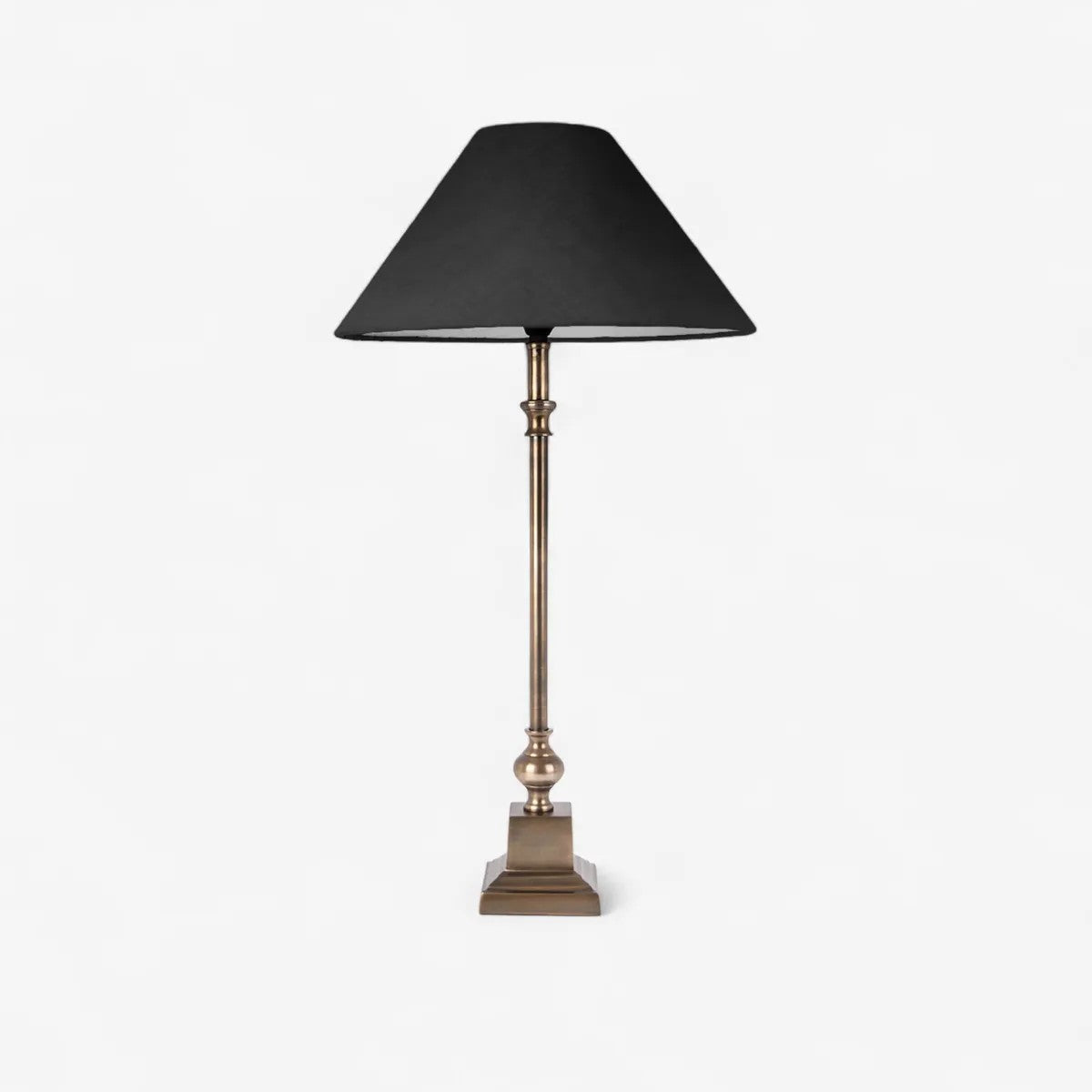 Table lamp with black shade and brass base on a white background