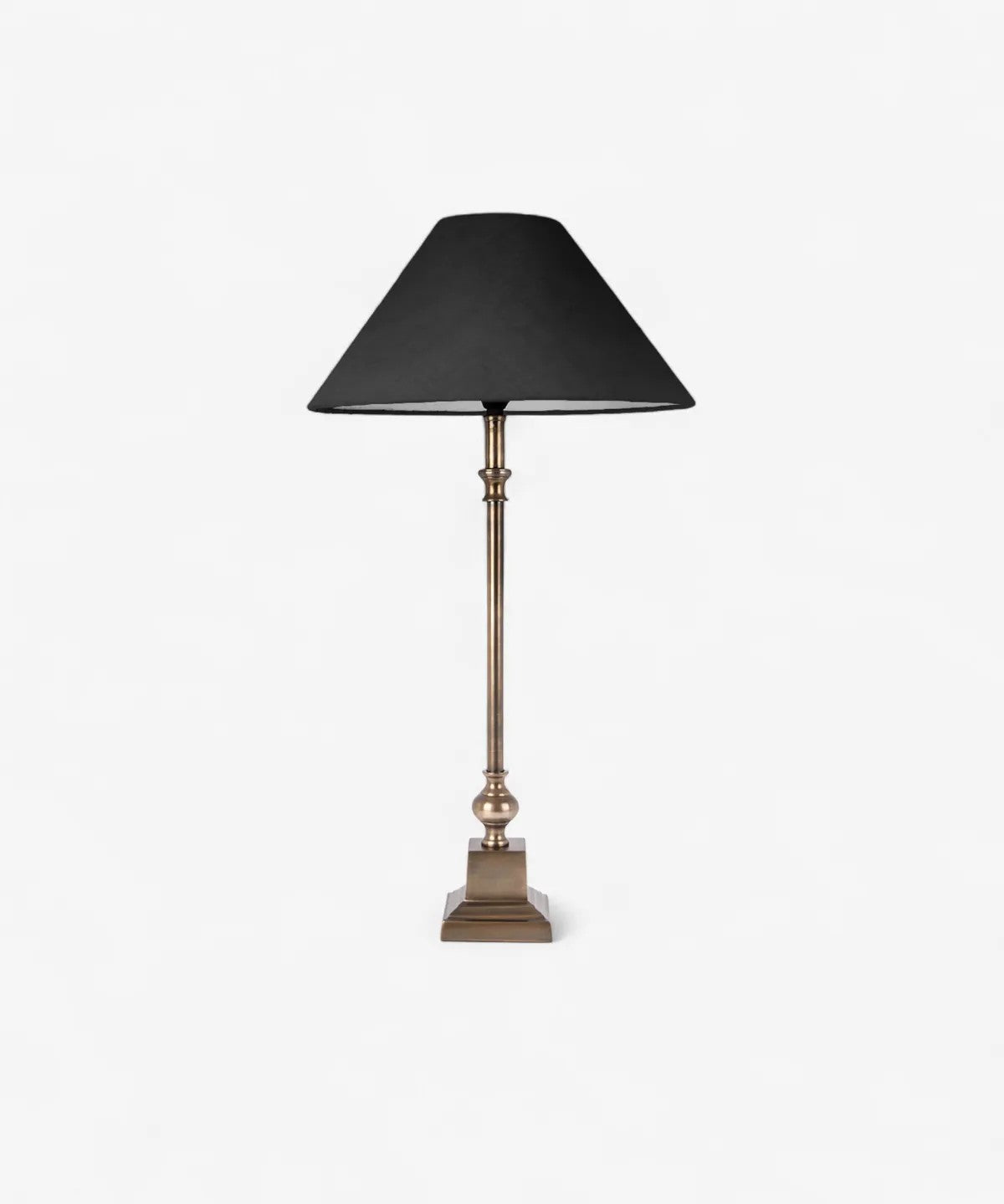 Table lamp with black shade and brass base on a white background