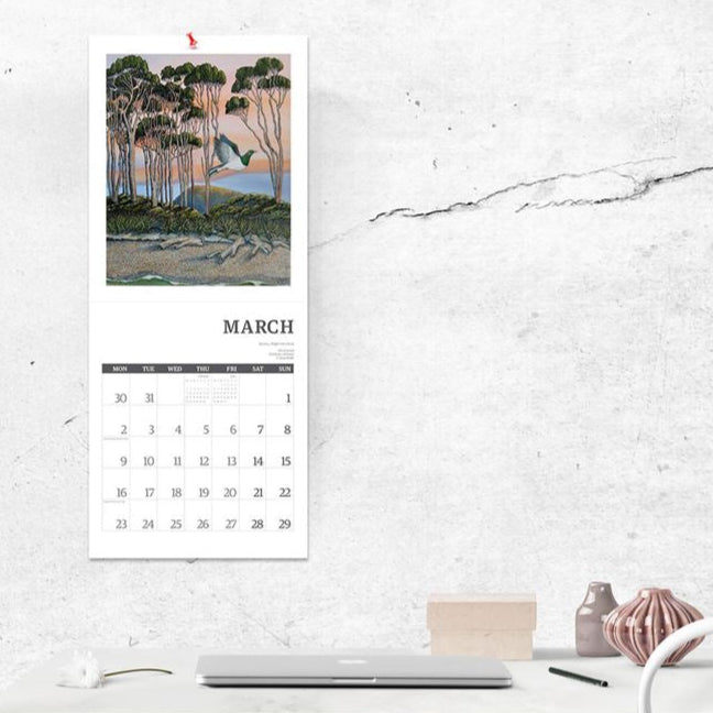 Calendar on a wall above a desk with a minimalistic design.