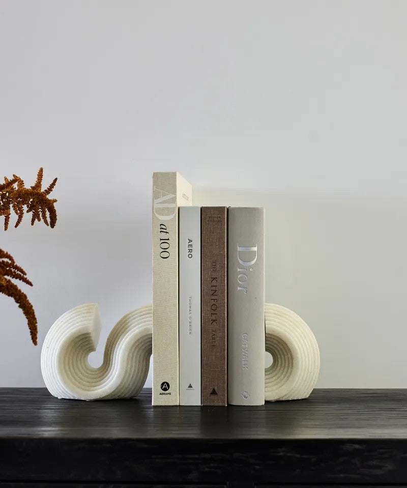 S shaped bookends displayed on bookshelf with books