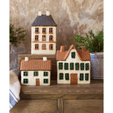 Set of miniature houses on a wooden surface with a neutral background