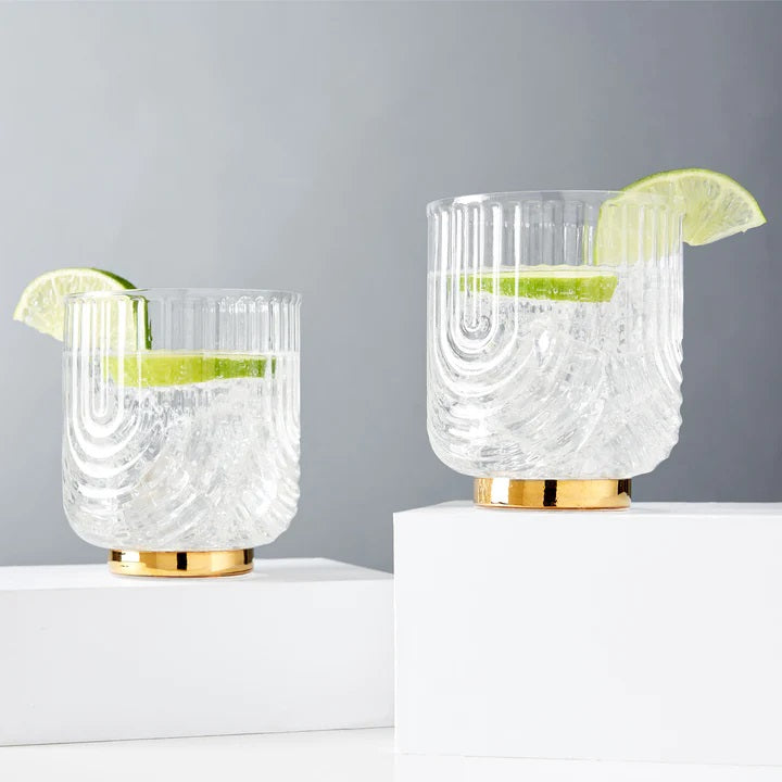 These 1920"s style elegant glasses feature a draping style glass offering a striking silhouette with polished gold plated base. Perfect for whiskey, margarita, negroni and more.  Boxed set of 2 Belmont Gatsby 12 oz Glasses.  High quality glass with gold electroplating.  Handwash only.